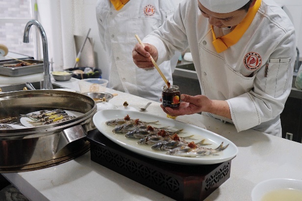 桌子上的碗里有一些人在厨房里做食物

描述已自动生成