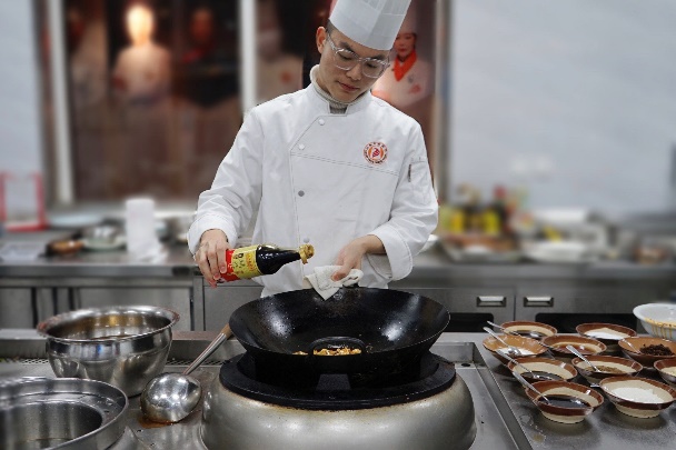 戴帽子的男人在厨房里做食物

描述已自动生成